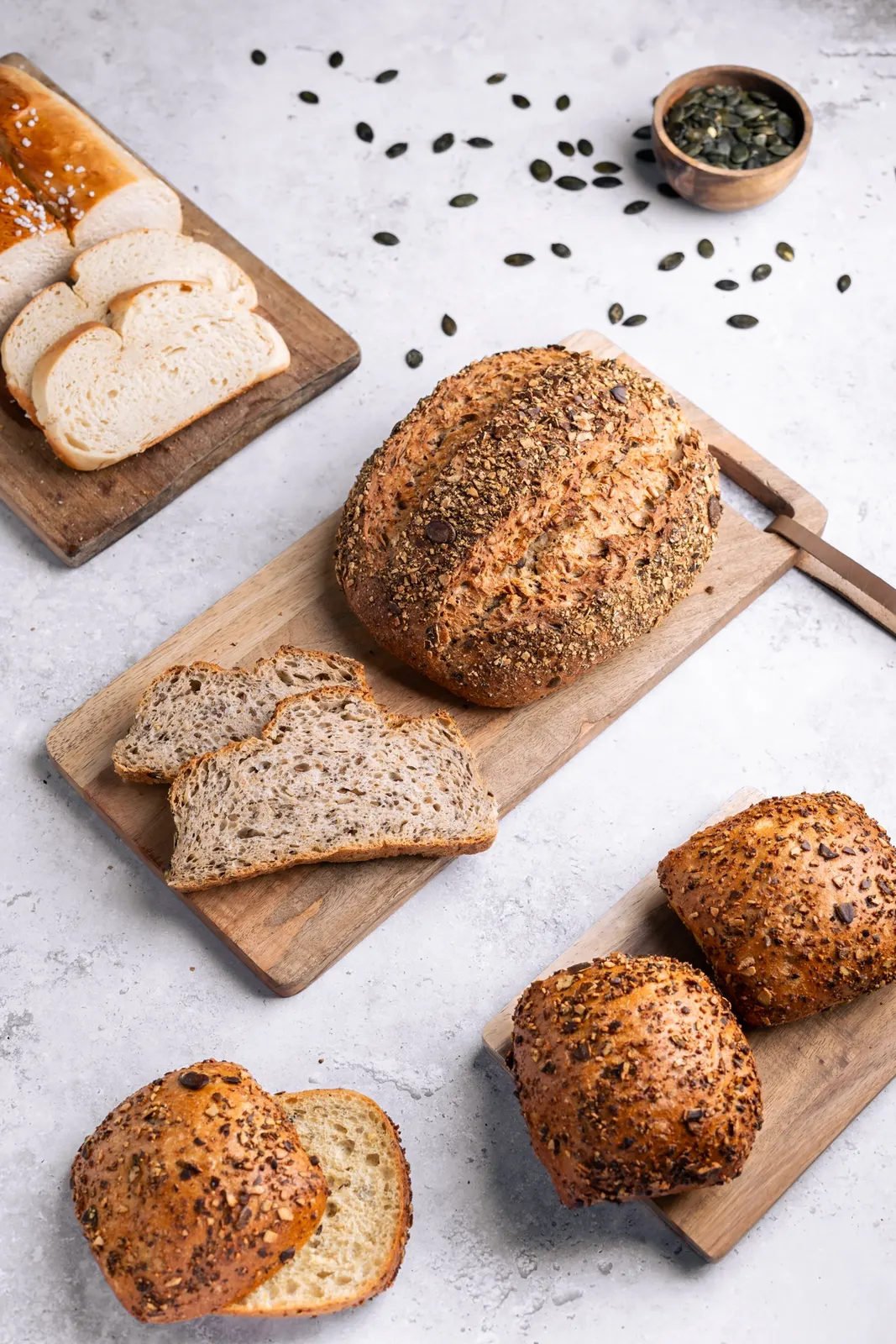 Bäckerei-Fotografie: Kürbiskernbrot auf Holzbrett, Balkenholl