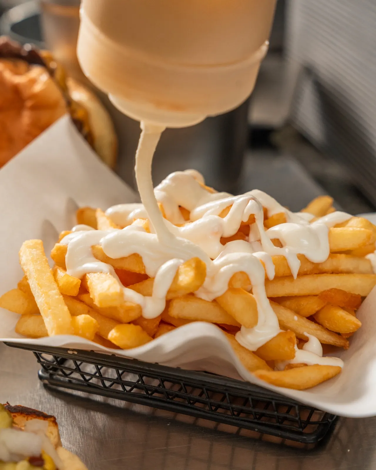 Food-Foto: Soße wird über Pommes gegeben